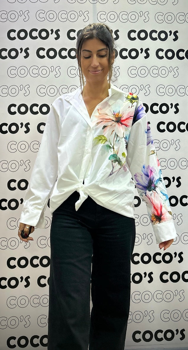 Camisa manga larga blanca con flores rosas y azules.