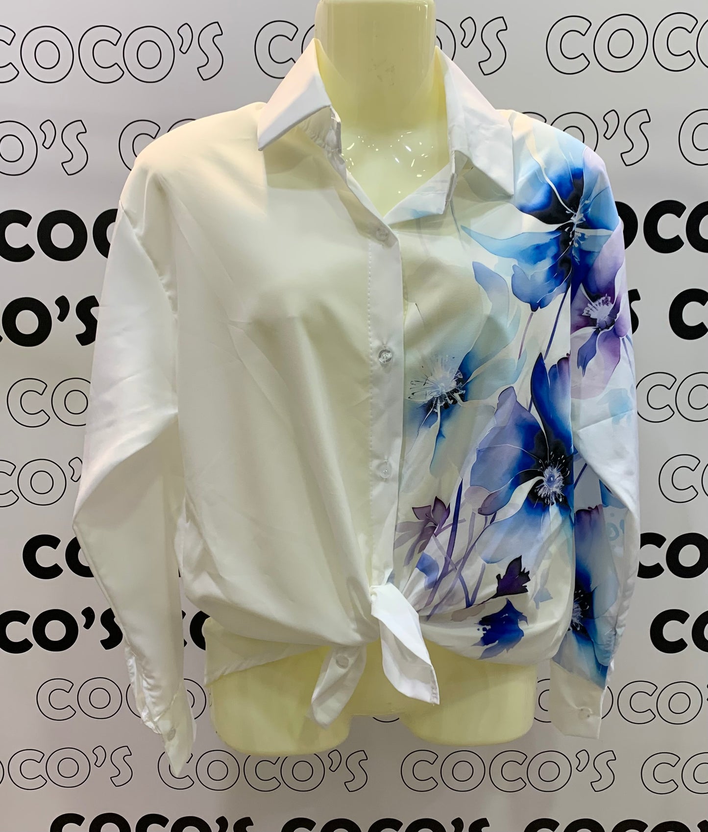 Camisa manga larga blanca con flores azules.