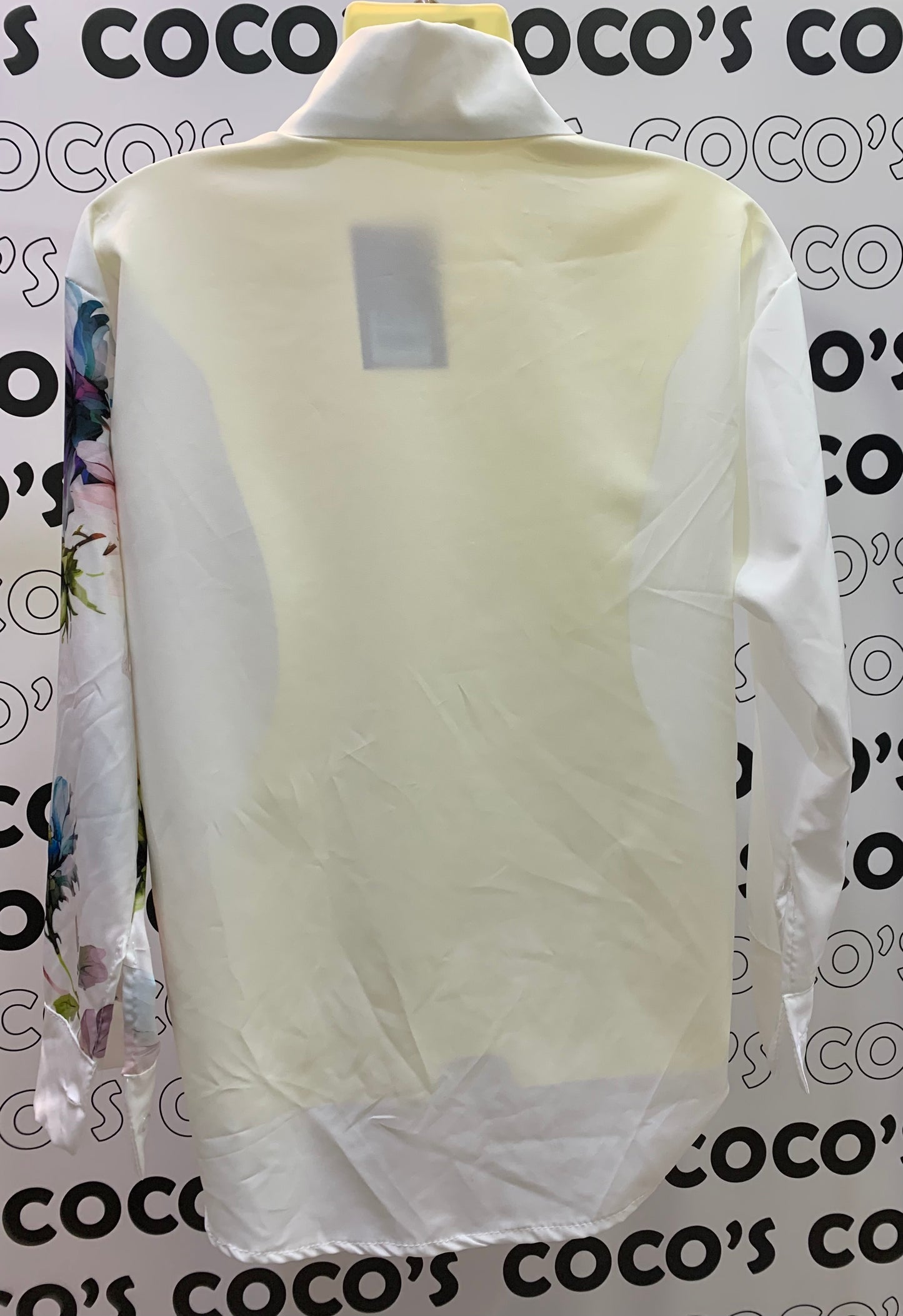 Camisa manga larga blanca con flores rosas y azules.