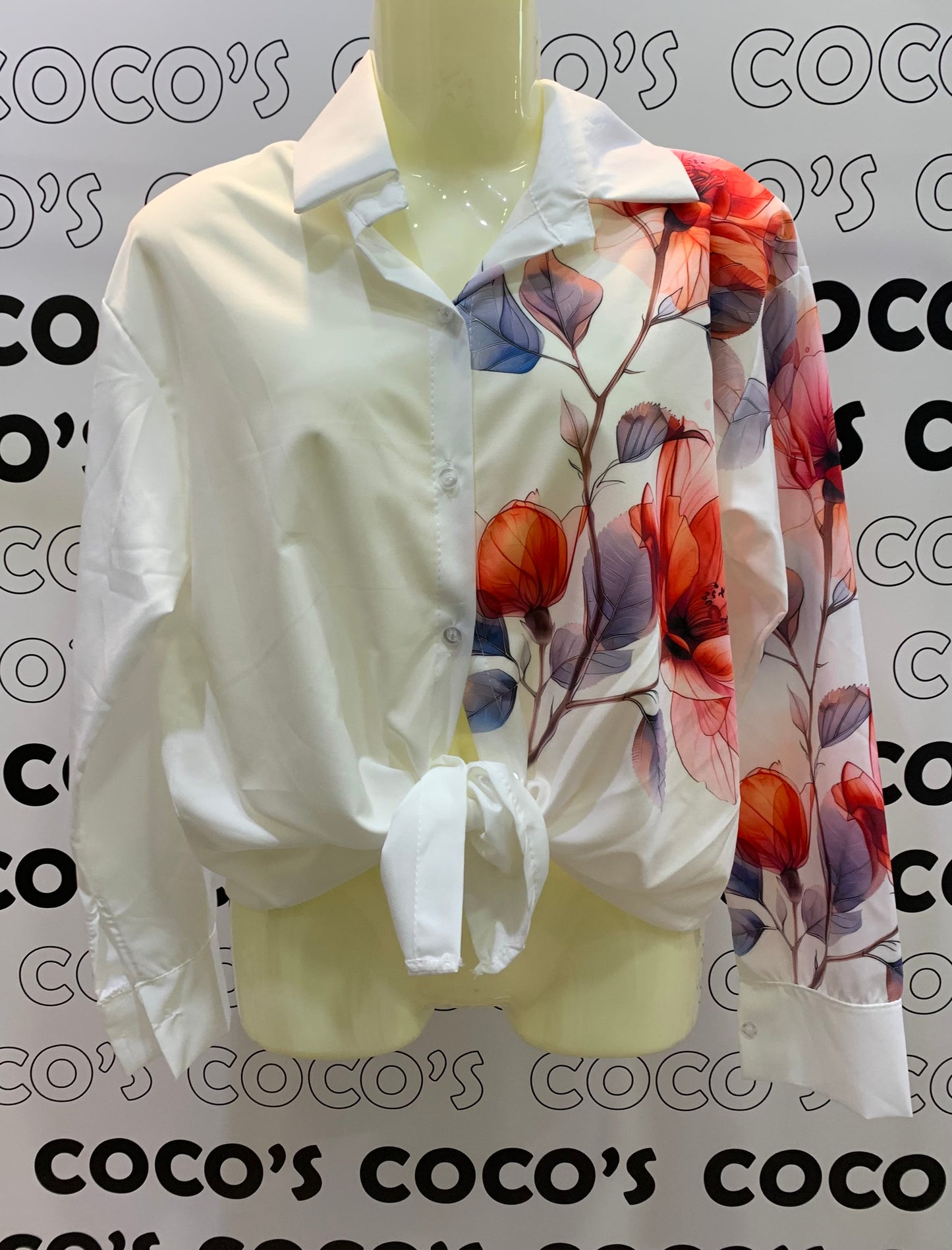Camisa botones con flores rojas en un lateral.