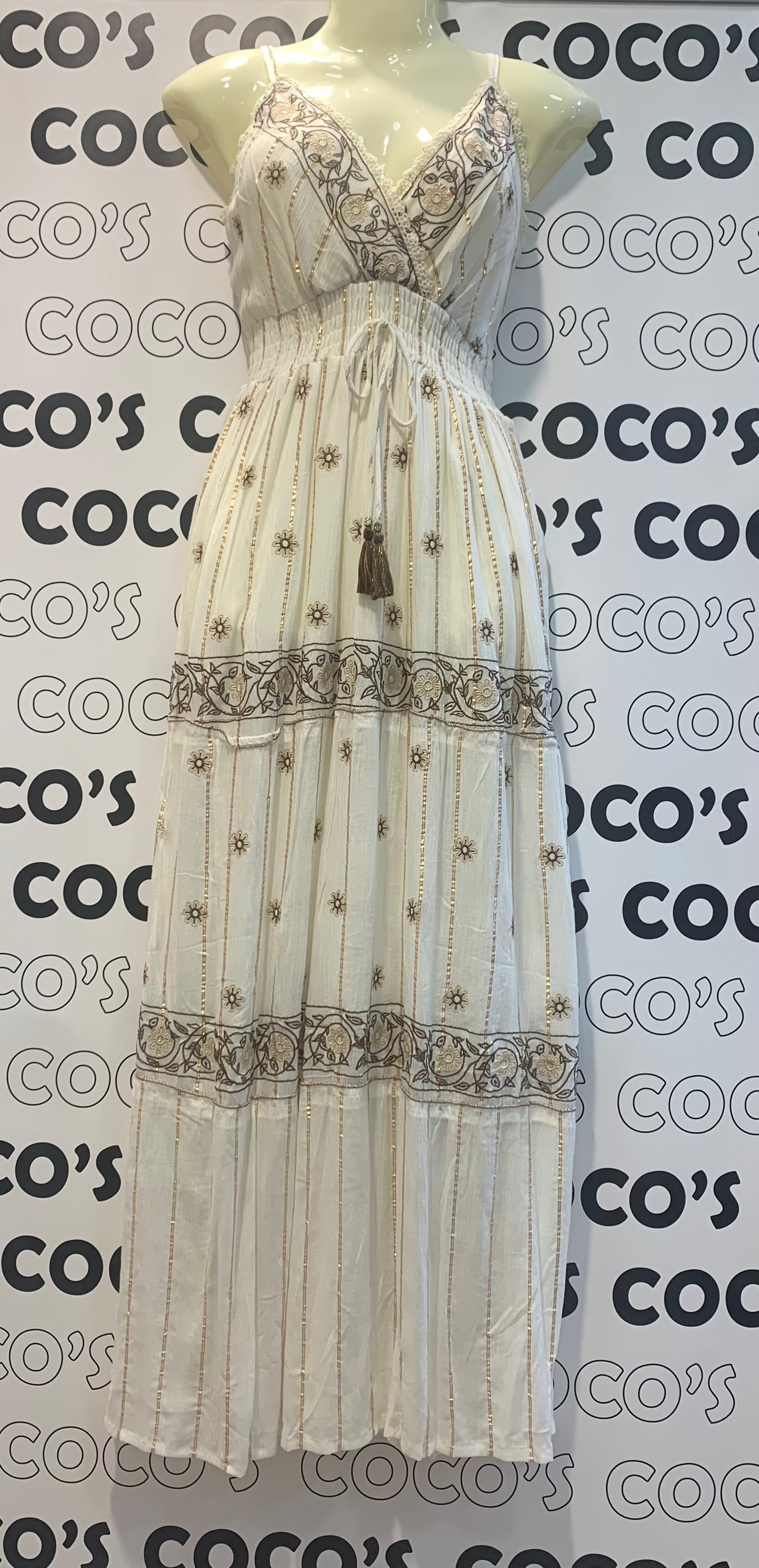 Vestido largo blanco con bordados marrón y beige.