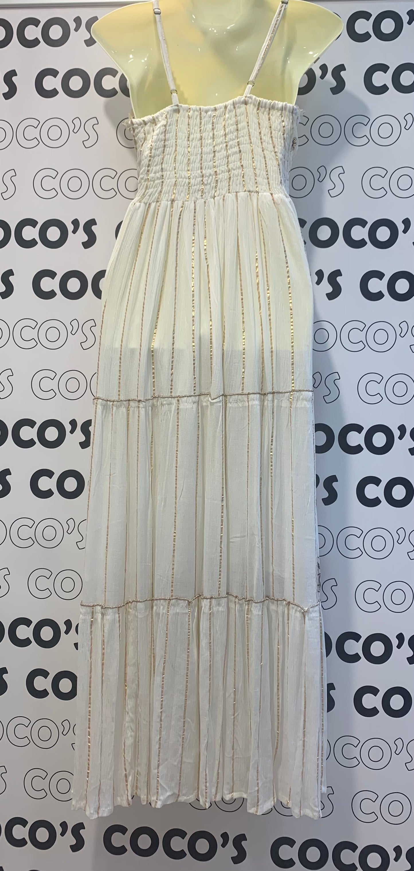 Vestido largo blanco con bordados marrón y beige.