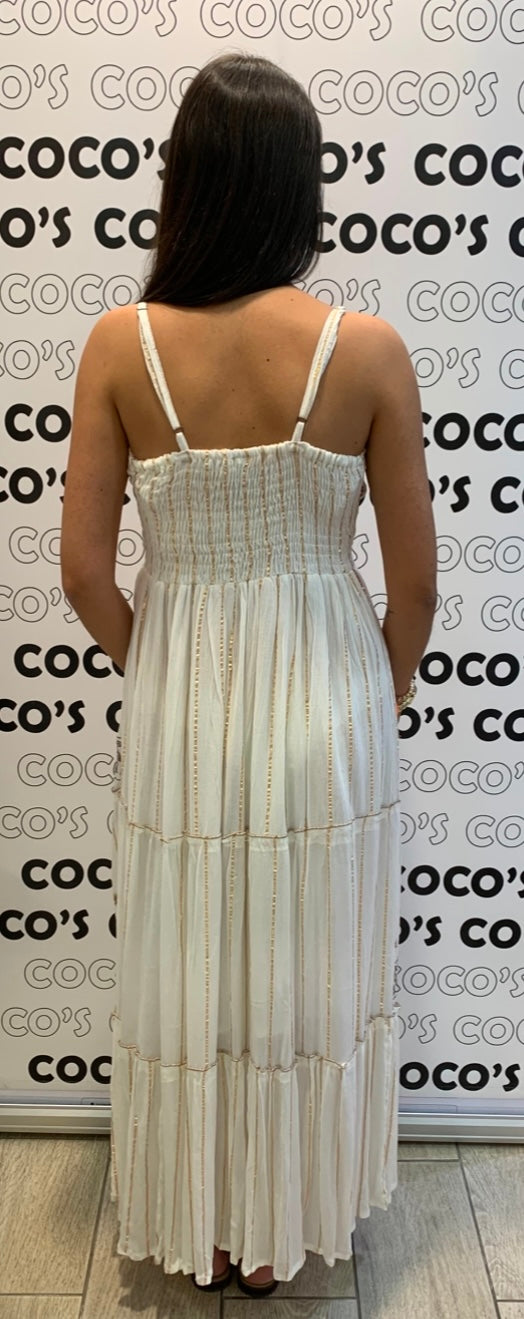 Vestido largo blanco con bordados marrón y beige.