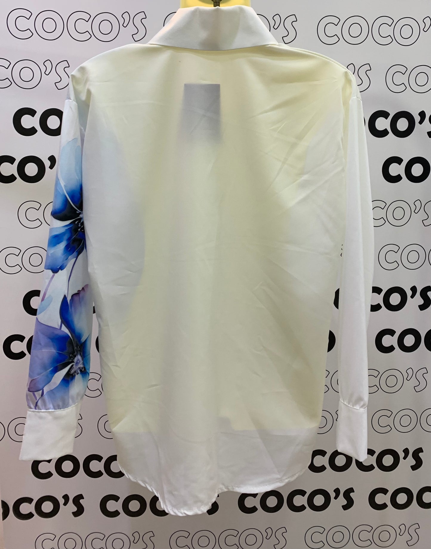 Camisa manga larga blanca con flores azules.