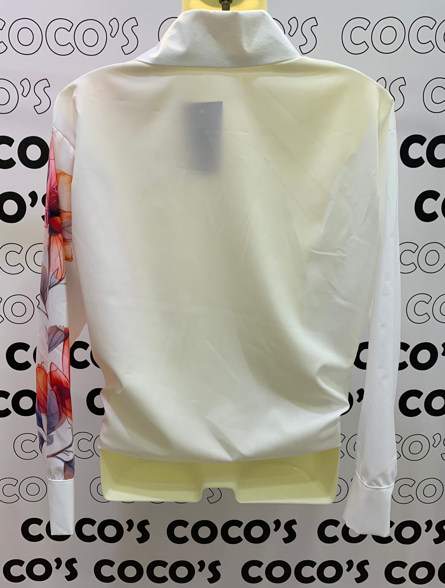 Camisa botones con flores rojas en un lateral.
